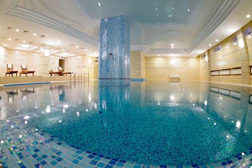 a swimming pool with a fountain in a building at GRAND OTRADA Hotel Resort & SPA in Odesa