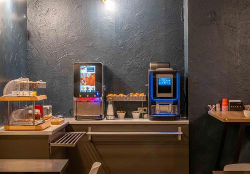 a counter with two vending machines in a restaurant at The Originals City, Hotel Ariane, Toulouse Sud Labège in Toulouse
