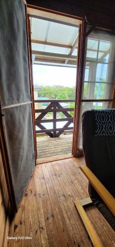 a room with a large window and a view of a deck at まちなかlodge ほしとたきび 一組様限定のお宿 レビューAward受賞 in Ōmuta