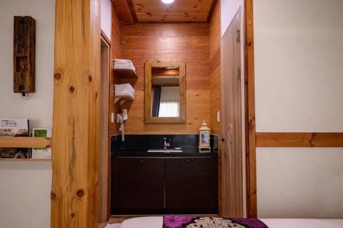 uma casa de banho com um lavatório e um espelho em Jeonju Wangyijimil Hanok Hotel em Jeonju
