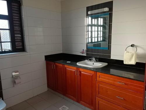 a bathroom with a sink and a mirror at Amigo apartments in Kisumu