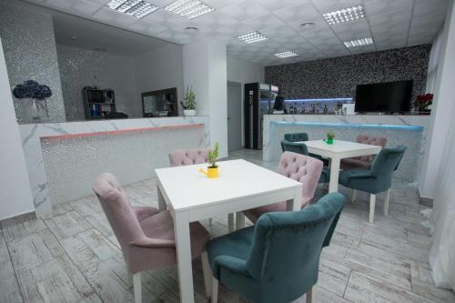 a restaurant with two tables and chairs and a counter at Magnific Hotel in Borş