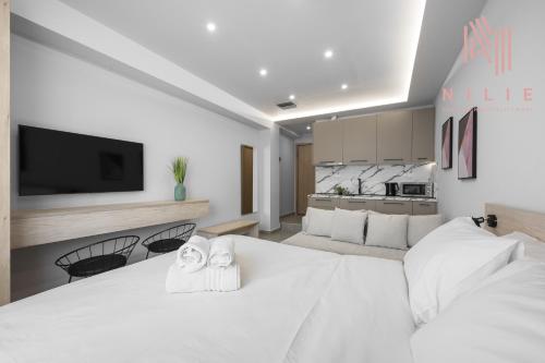 a bedroom with a large white bed with towels at Pantheon, Nilie Hospitality MGMT in Thessaloniki