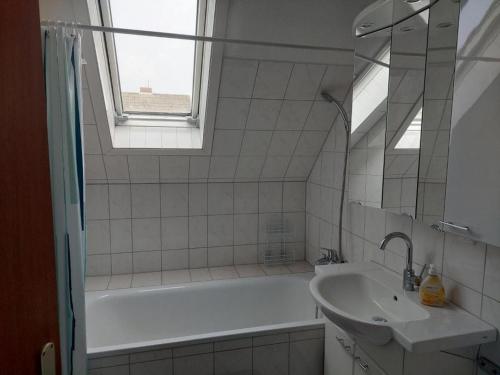 bagno con vasca, lavandino e finestra di Ferienwohnung Abendsonne, Winsen a Winsen