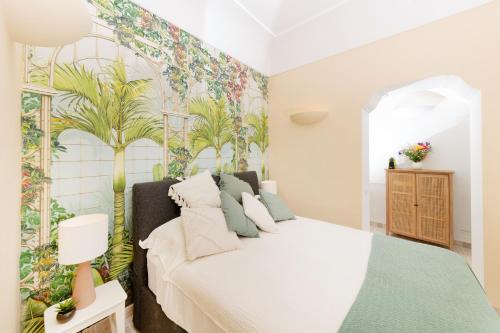 een slaapkamer met een bed met tropisch behang bij Appartamento a Capri a pochi passi dalla Piazzetta in Capri