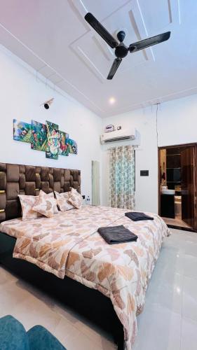 1 dormitorio con 1 cama grande y ventilador de techo en Nirmal sadan Homestay, en Kāman