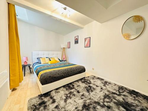 Schlafzimmer mit einem Bett, einem Spiegel und einem Teppich in der Unterkunft Appartement Confidentiel in Laon