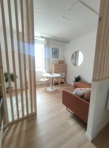 ein Wohnzimmer mit einem Sofa und einem Tisch in der Unterkunft Le Studio in Saint-Gilles