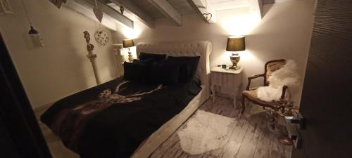 1 dormitorio con cama, lámpara y silla en Casa relax, en Aosta