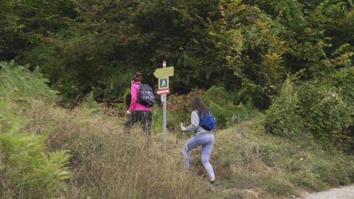 two people walking up a hill near a sign on a trail at Ethnic Grand Room -Tara Place in Mojkovac