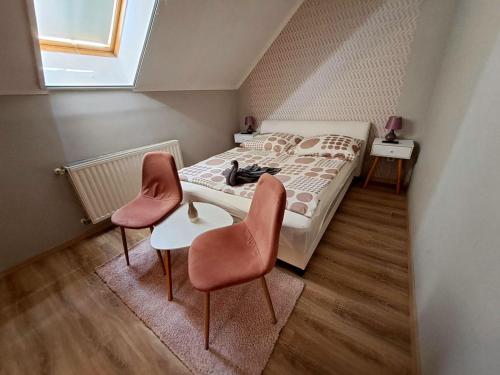 ハイドゥソボスローにあるBerta Panzióの小さなベッドルーム(ベッド1台、椅子2脚付)