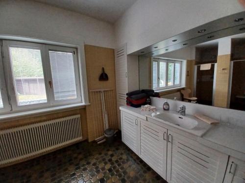 a bathroom with a sink and a large mirror at Villa Romy mit 3 Gästezimmer in Bad Ischl