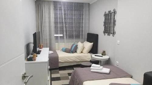 a small room with two beds and a bathroom at Apartman AMI in Tuzla