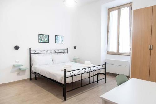 um quarto com uma cama, uma mesa e uma janela em Domus Viola in San Giovanni em Roma