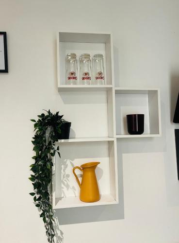 une étagère avec des tasses et un vase sur un mur dans l'établissement Calm And Cozy, à Paris