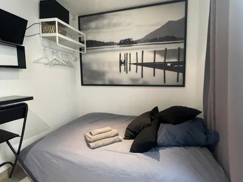 - un lit dans une chambre avec une photo sur le mur dans l'établissement Calm And Cozy, à Paris