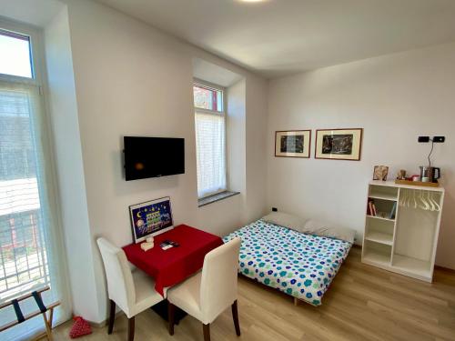 a room with a table and a bed in it at Notte di Note - home hospitality in Busto Arsizio