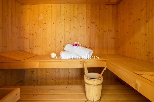 una sauna de madera con una toalla y un cubo en Villa con piscina e spa privata, en San Michele di Ganzaria