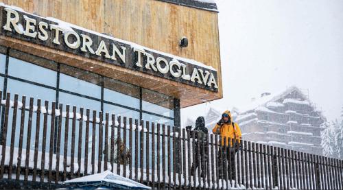 two people standing outside of a restaurant in the snow at Ethnic Grand Room -Tara Place in Mojkovac