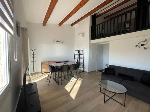 uma sala de estar com um sofá, uma mesa e cadeiras em Apt neuf à 1 min de la mer à Sausset em Sausset-les-Pins