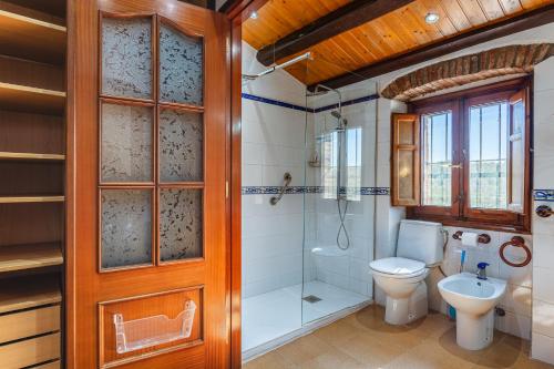 a bathroom with a toilet and a shower and a sink at Masia Can Vilar in Maçanet de la Selva
