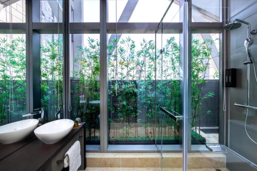 baño con 2 lavabos y ducha de cristal en Starphire Hotel, en Hong Kong