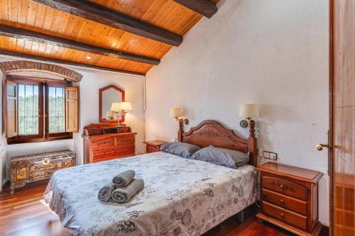 a bedroom with a bed with two towels on it at Masia Can Vilar in Maçanet de la Selva