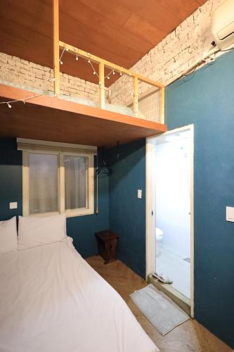 a bedroom with a bed and a blue wall at SISnBRO Guesthouse in Seoul
