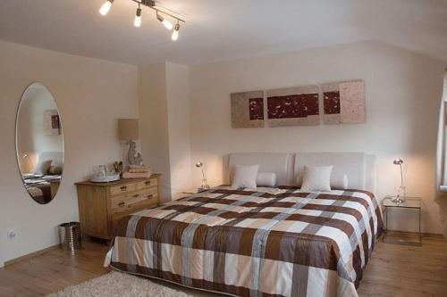 Schlafzimmer mit einem Bett, einer Kommode und einem Spiegel in der Unterkunft Harzhaus Romantica in Hahnenklee-Bockswiese