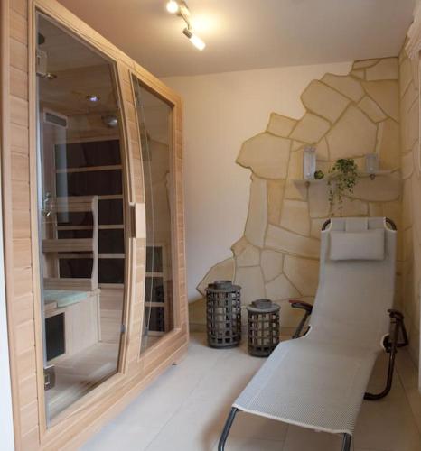 a white chair in a room with a wall at Harzhaus Romantica in Hahnenklee-Bockswiese