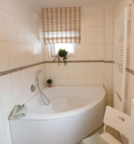 a white bath tub in a bathroom with a window at Harzhaus Romantica in Hahnenklee-Bockswiese