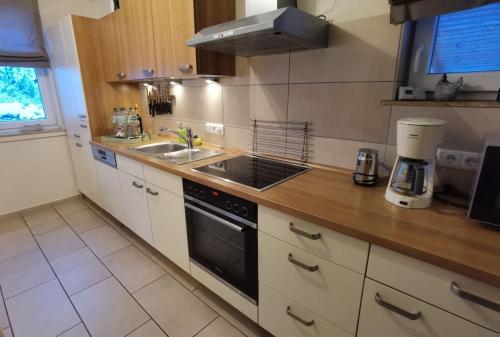 a kitchen with a sink and a stove at Harzhaus Romantica in Hahnenklee-Bockswiese