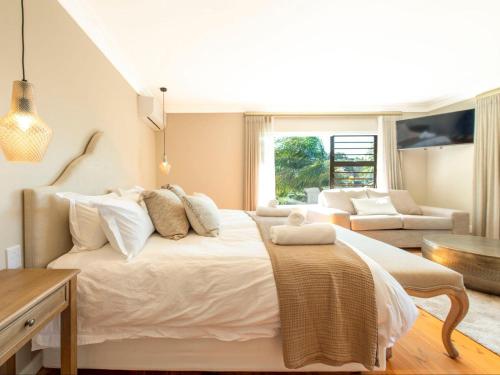 a bedroom with a large bed and a living room at Aan de Paarlberg in Paarl