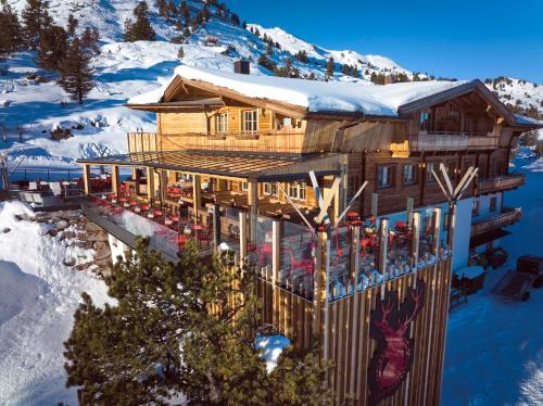 ein Blockhaus in den Bergen mit Schnee in der Unterkunft Berggasthof Platzlalm in Kaltenbach