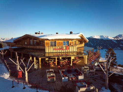 een groot houten huis met sneeuw op het dak bij Berggasthof Platzlalm in Kaltenbach