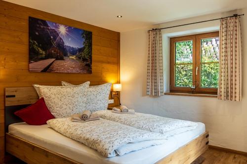 um quarto com uma grande cama branca e uma janela em Haus Lärche em Schönau am Königssee
