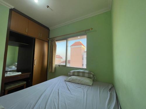 ジャカルタにあるHighlander Apartemen City Resortの小さなベッドルーム(ベッド1台、窓付)