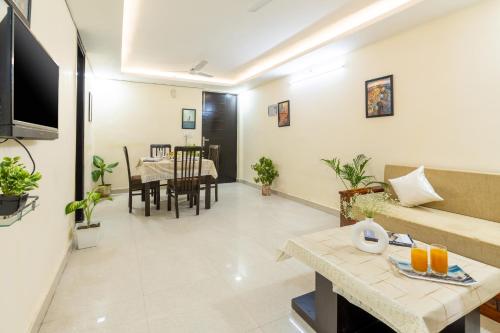 a living room with a couch and a table at Homlee-Jumbo 1BHK-2AC-Kitchen-Lift-Parking-Tapovan in Rishīkesh