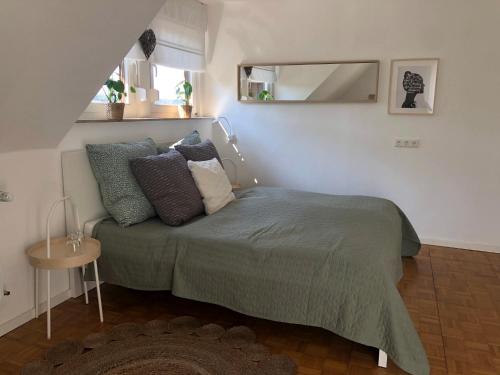 een slaapkamer met een bed met kussens en een spiegel bij Ferienwohnung Eifelglück - b44654 in Pelm