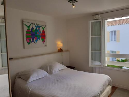 ユー島にあるHôtel L'Escaleのベッドルーム(白いベッド1台、窓付)