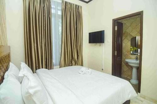 a bedroom with a white bed and a sink at GILI VIEW By Maza in Teluk Nara