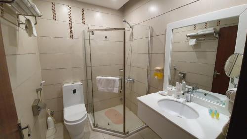 ein Bad mit einer Dusche, einem Waschbecken und einem WC in der Unterkunft منتجع شاطئ الدولفين للإيواء السياحي in Yanbu