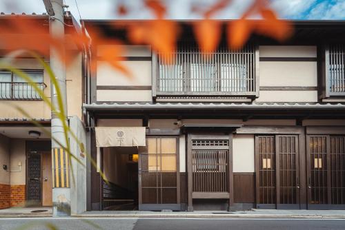 京都的住宿－谷町君・星屋旅館・神泉ノ宿　二条城，街道上设有棕色门窗的建筑