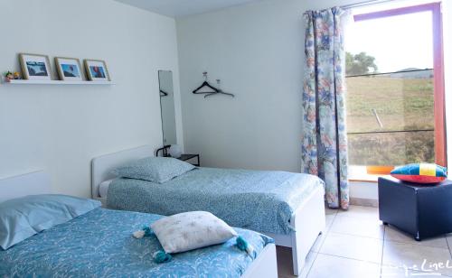 a bedroom with two beds and a window at Au balcon de la Gaume in Meix-devant-Virton