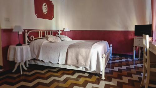 a bedroom with a bed and a table with a clock at Cà del Vescovo in Imperia