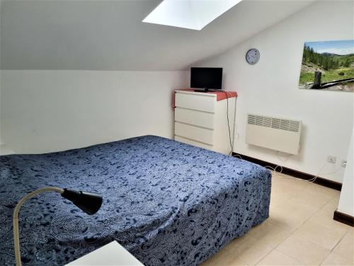 a bedroom with a bed and a dresser and a window at 2 pièces au pied des pistes in Guillaumes