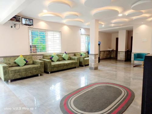 a living room with couches and a rug on the floor at De Crown Luxury Hotel in Kākināda