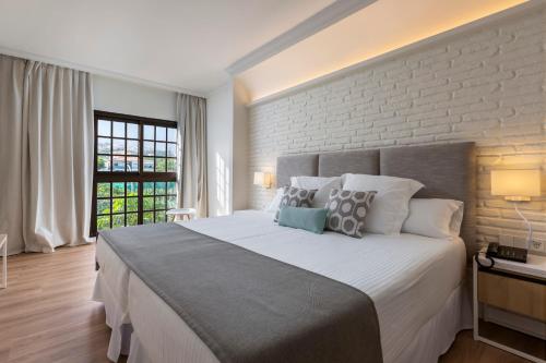 a bedroom with a large bed and a brick wall at AluaSoul Orotava Valley - Adults Only in Puerto de la Cruz