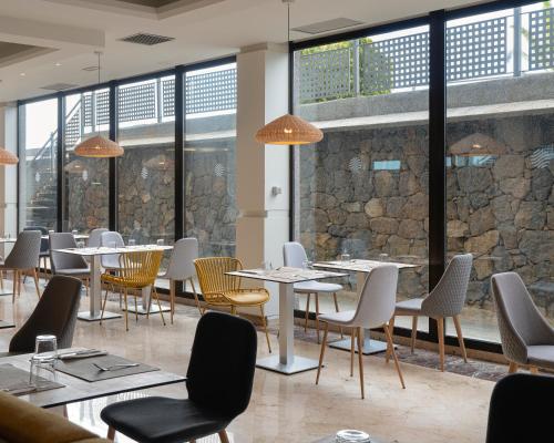 a restaurant with tables and chairs and windows at AluaSoul Orotava Valley - Adults Only in Puerto de la Cruz