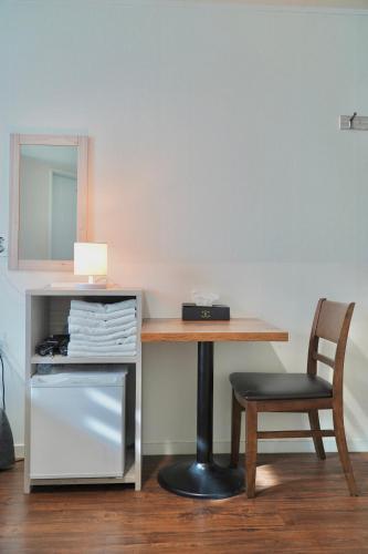 a desk with a chair next to a table with a mirror at Seoul Grand Hostel EWHA Univ in Seoul